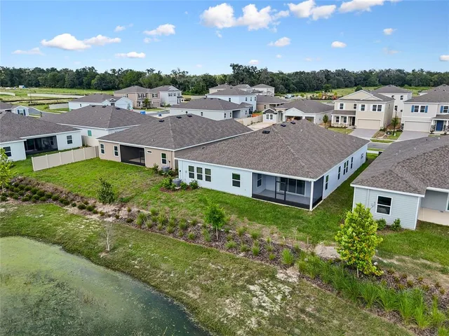 an aerial view of residential houses with outdoor space and trees