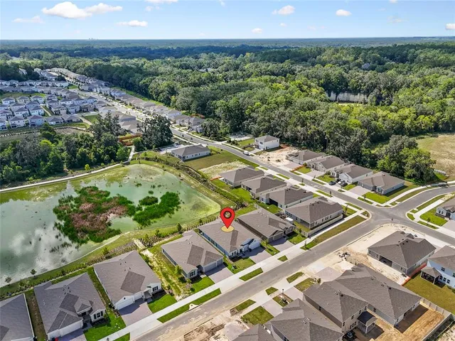 an aerial view of a house with a swimming pool and mountains