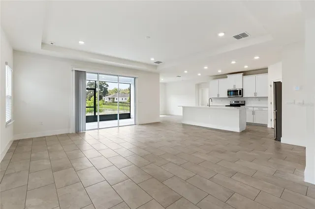 a view of kitchen with granite countertop cabinets and refrigerator