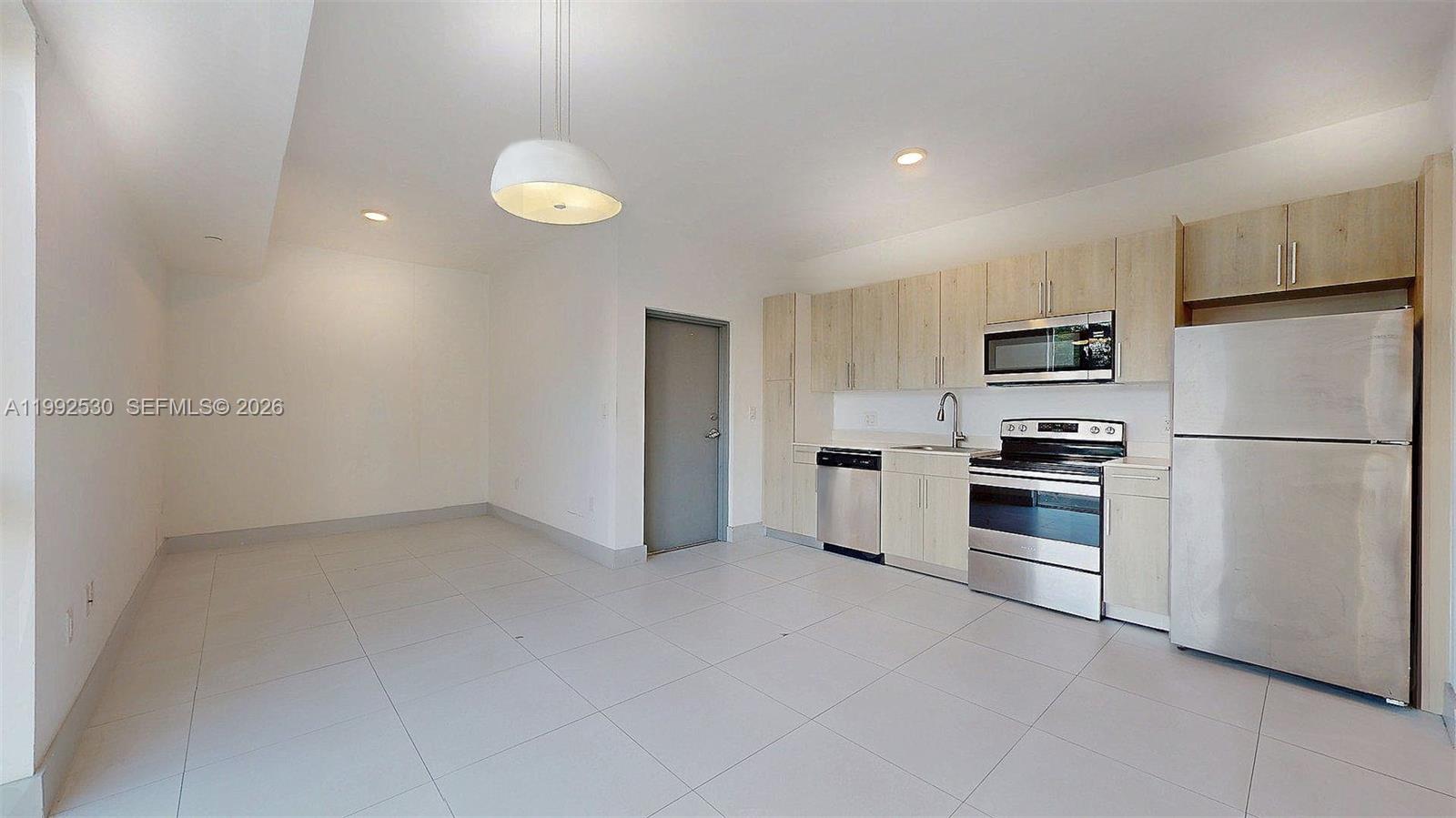 519 Southwest 5th Avenue, Unit 203 Miami, FL 33130 - Photo 12 of 26 a kitchen with white cabinets and stainless steel appliances