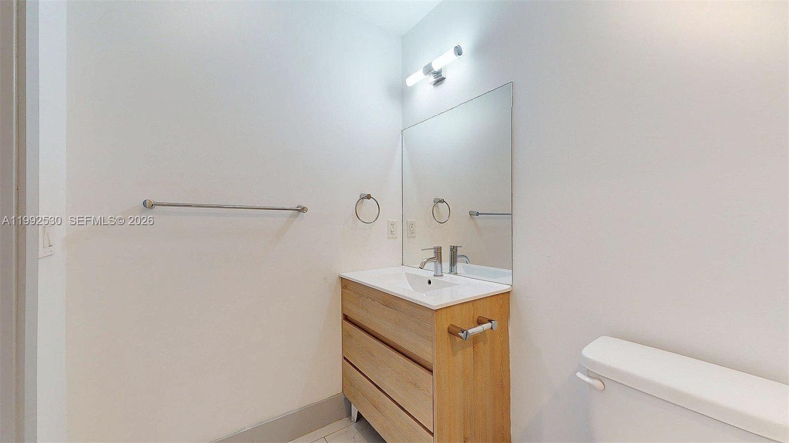 519 Southwest 5th Avenue, Unit 203 Miami, FL 33130 - Photo 16 of 26 a bathroom with a sink a toilet and vanity