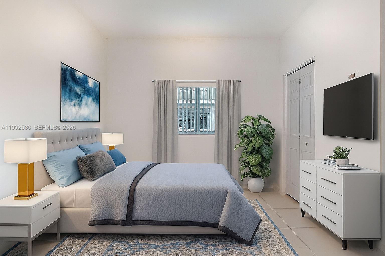 519 Southwest 5th Avenue, Unit 203 Miami, FL 33130 - Photo 19 of 26 a bedroom with a bed and a flat screen tv