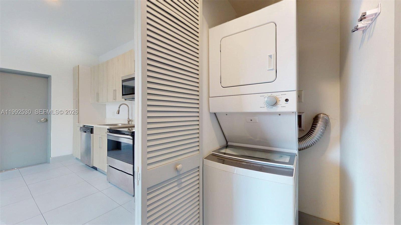 519 Southwest 5th Avenue, Unit 203 Miami, FL 33130 - Photo 25 of 26 a kitchen with a refrigerator and white cabinets