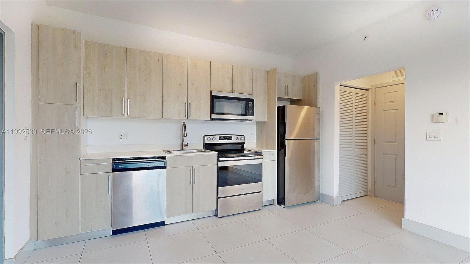 519 Southwest 5th Avenue, Unit 203 Miami, FL 33130 - Photo 4 of 26 a kitchen with stainless steel appliances granite countertop a refrigerator and a stove top oven