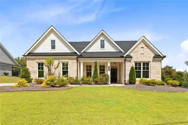 a front view of a house with lots of plants and seating area
