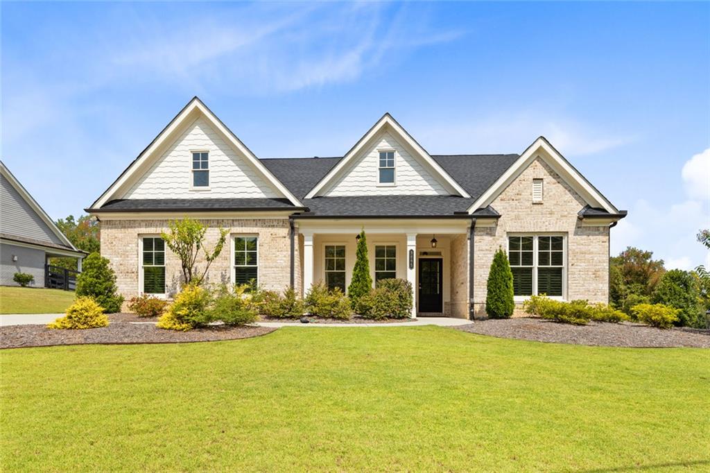 a front view of a house with lots of plants and seating area