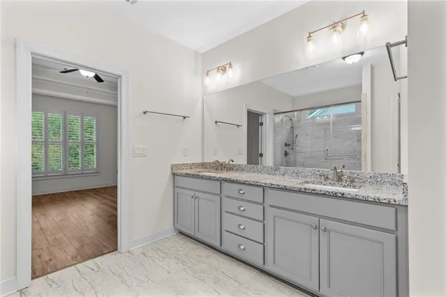 a bathroom with a granite countertop sink a mirror and shower