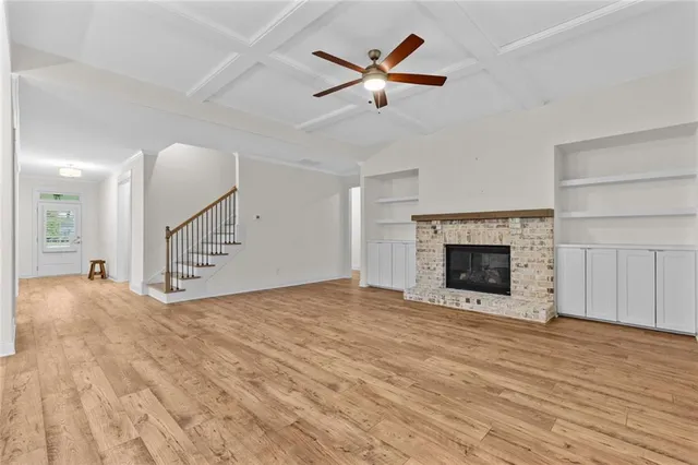 a view of a livingroom with a ceiling fan a fireplace and a ceiling fan