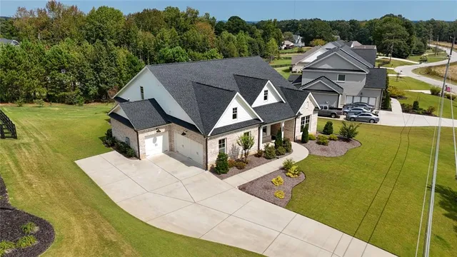 an aerial view of a house with swimming pool and outdoor seating