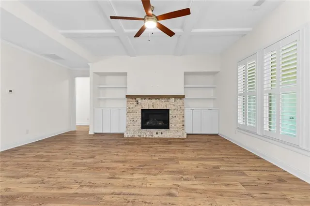 an empty room with windows and fireplace