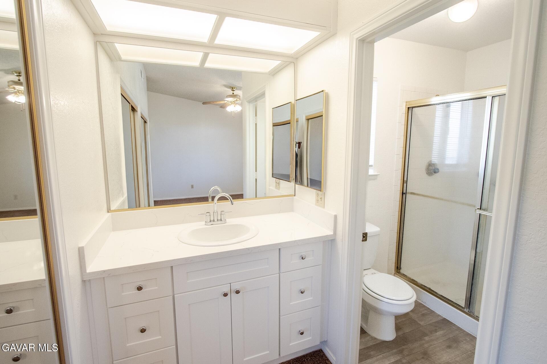 44318 33rd Street West Lancaster, CA 93536 - Photo 22 of 29 a bathroom with a sink a toilet a large mirror and shower