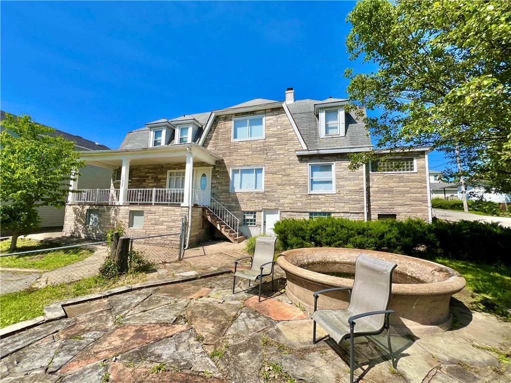 a view of a patio with table and chairs and wooden fence