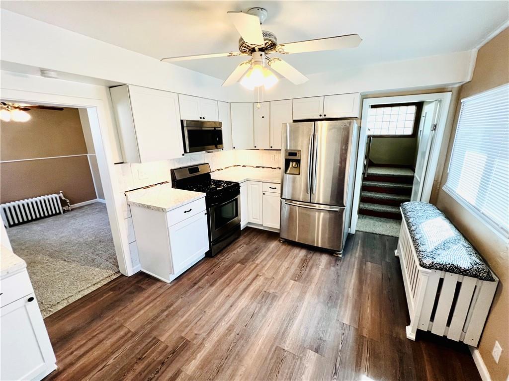 1032 Main Street Republic, PA 15475 - Photo 6 of 39 a kitchen with wooden floors and stainless steel appliances