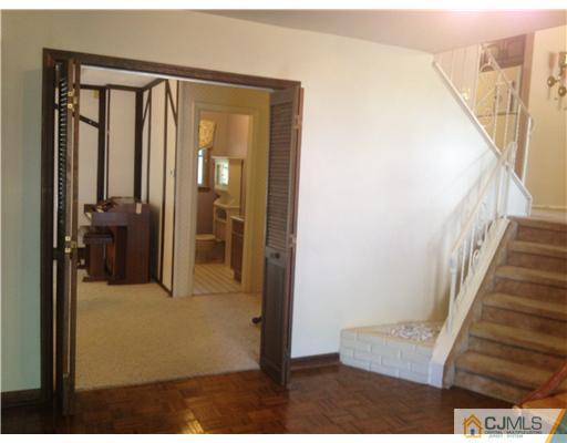 29 Sherwood Road Edison, NJ 08820 - Photo 4 of 12 a view of a hallway with wooden floor and staircase