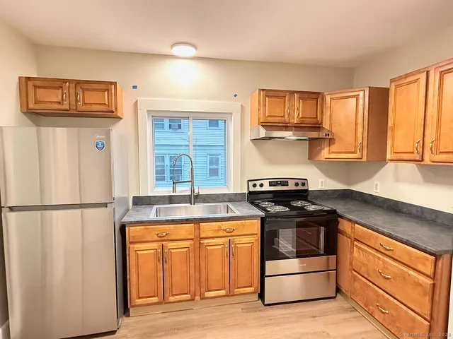 a kitchen with stainless steel appliances granite countertop a stove and a refrigerator