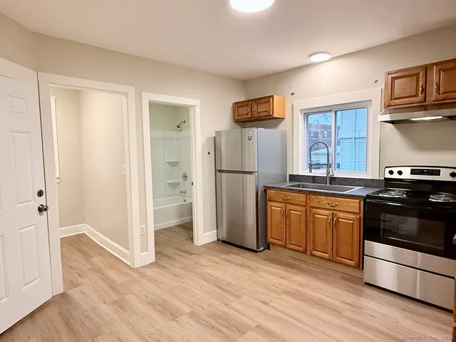 a kitchen with stainless steel appliances granite countertop a refrigerator and a stove top oven