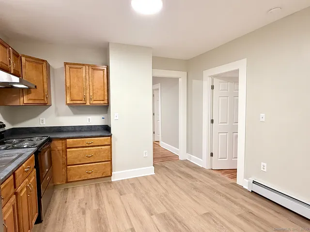 a kitchen with granite countertop wooden floors and white stainless steel appliances