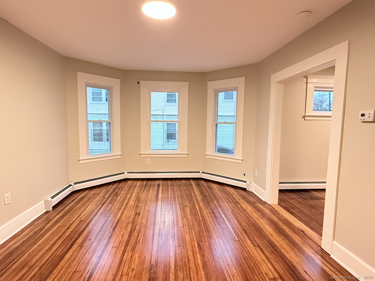 69 South Street Hartford, CT 06114 - Photo 7 of 20 a view of an empty room with wooden floor and a window