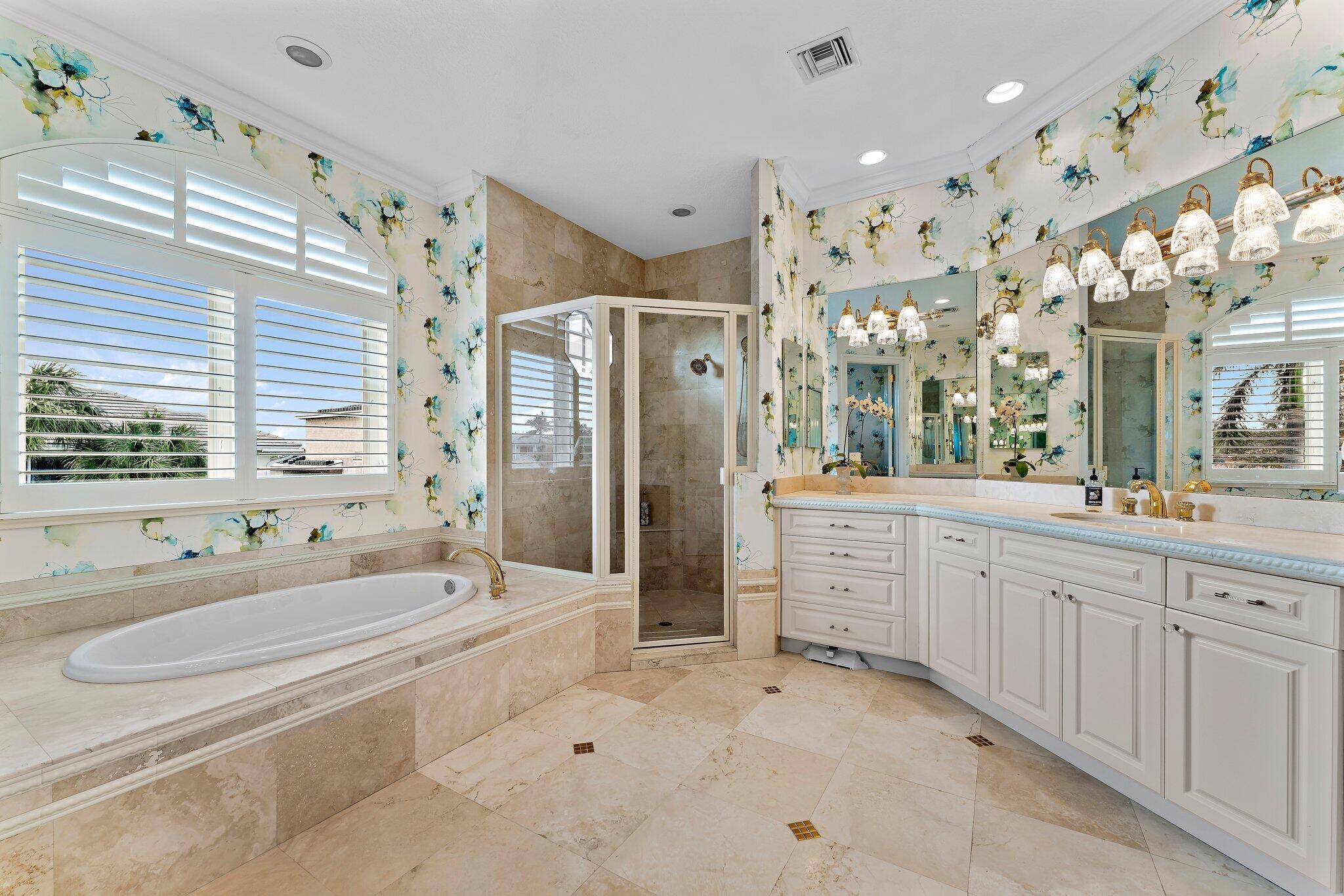 17129 Southeast Limerick Court Tequesta, FL 33469 - Photo 42 of 80 a bathroom with a granite countertop sink a large mirror and a bathtub with shower