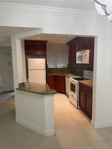 a kitchen with stainless steel appliances granite countertop a stove and a microwave
