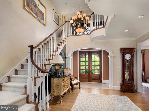 a view of staircase with wooden floor and a chandelier