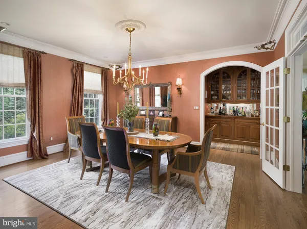 a dining room with furniture a chandelier and wooden floor