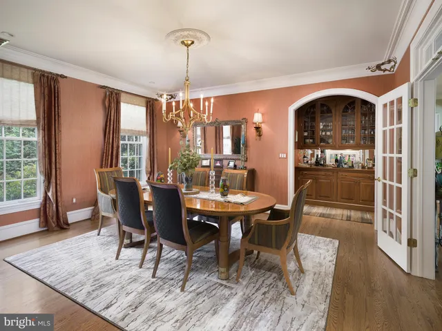 a dining room with furniture a chandelier and wooden floor