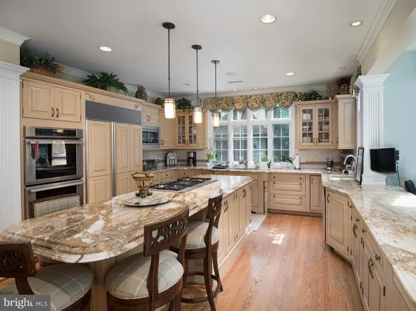 a kitchen with stainless steel appliances granite countertop a stove refrigerator and cabinets