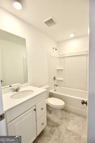 a large kitchen with kitchen island a sink a stove a refrigerator and white cabinets