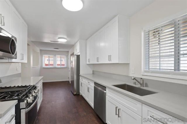 a kitchen with white cabinets and white appliances