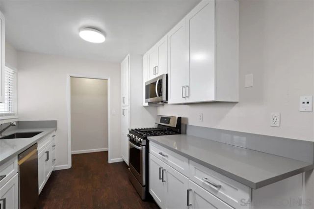 a view of empty room with wooden floor and cabinet