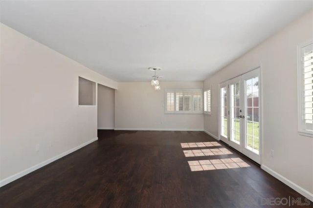 a view of an empty room with a window and fireplace