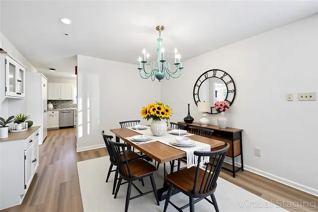a view of a dining room with furniture a chandelier and wooden floor