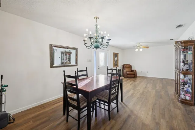 a view of a dining room with furniture a chandelier and wooden floor