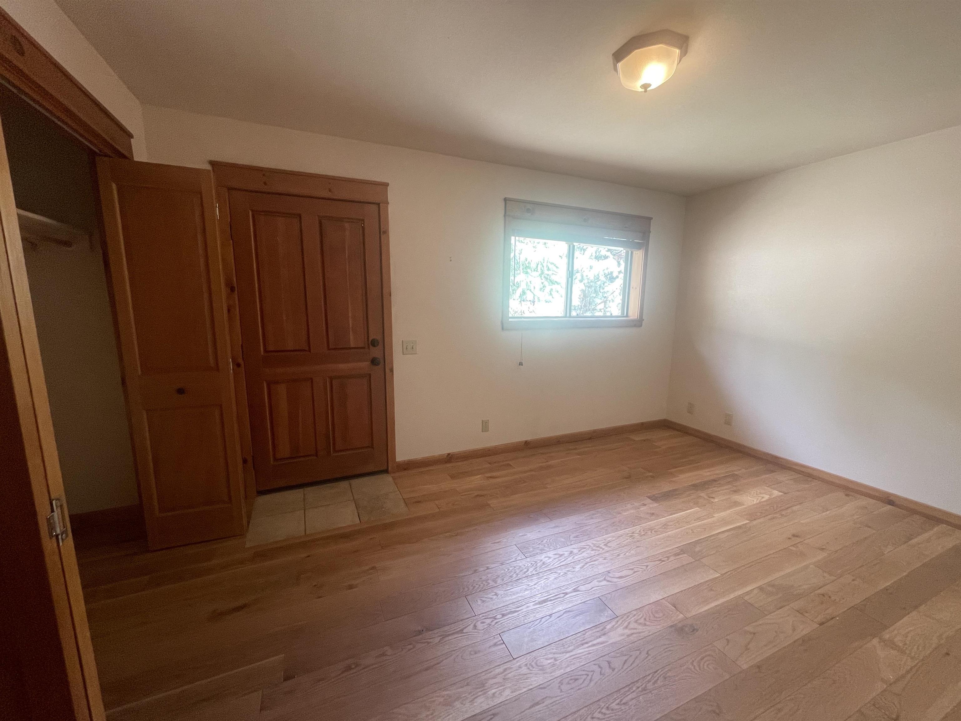 117 Summit Road, Unit 2 Bishop, CA 93514 - Photo 12 of 19 an empty room with wooden floor and windows