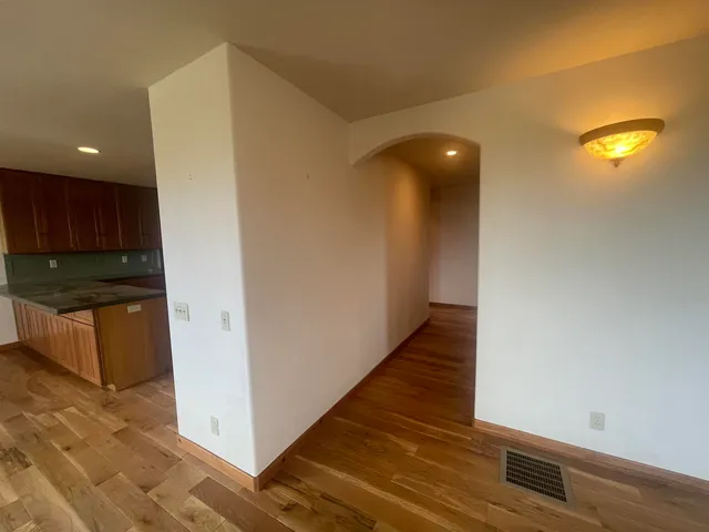 a view of a hallway with wooden floor and staircase