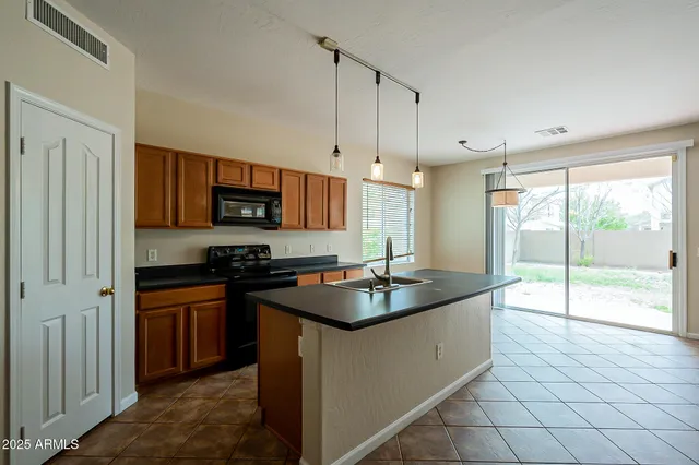 a kitchen with kitchen island granite countertop a sink a stove and a granite counter top