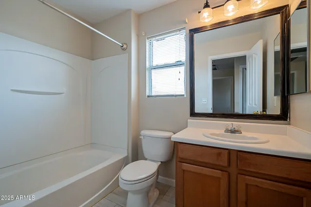 a spacious bathroom with a tub sink and mirror