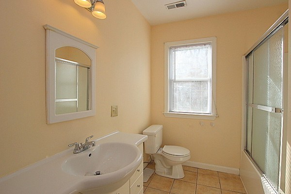 111 Silver Brook Road Milton, MA 02186 - Photo 14 of 28 a bathroom with a toilet a sink a mirror and a window