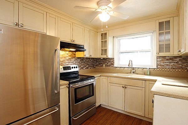 111 Silver Brook Road Milton, MA 02186 - Photo 5 of 28 a kitchen with stainless steel appliances a sink cabinets and a window