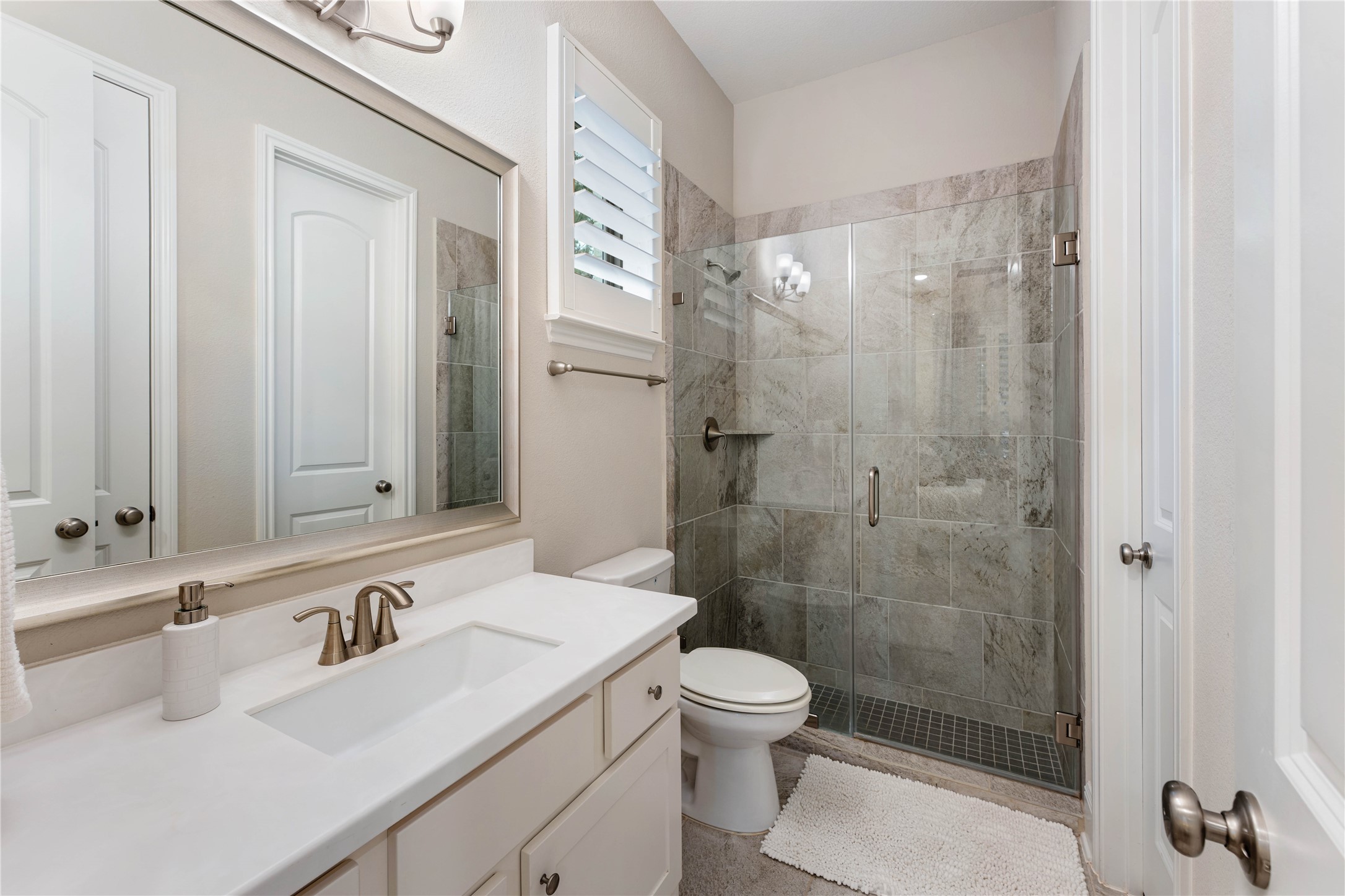 155 Rockwell Park Spring, TX 77389 - Photo 7 of 41 Attached guest bathroom showcases a glass-enclosed shower, elegant tiles, and a spacious vanity with ample storage.