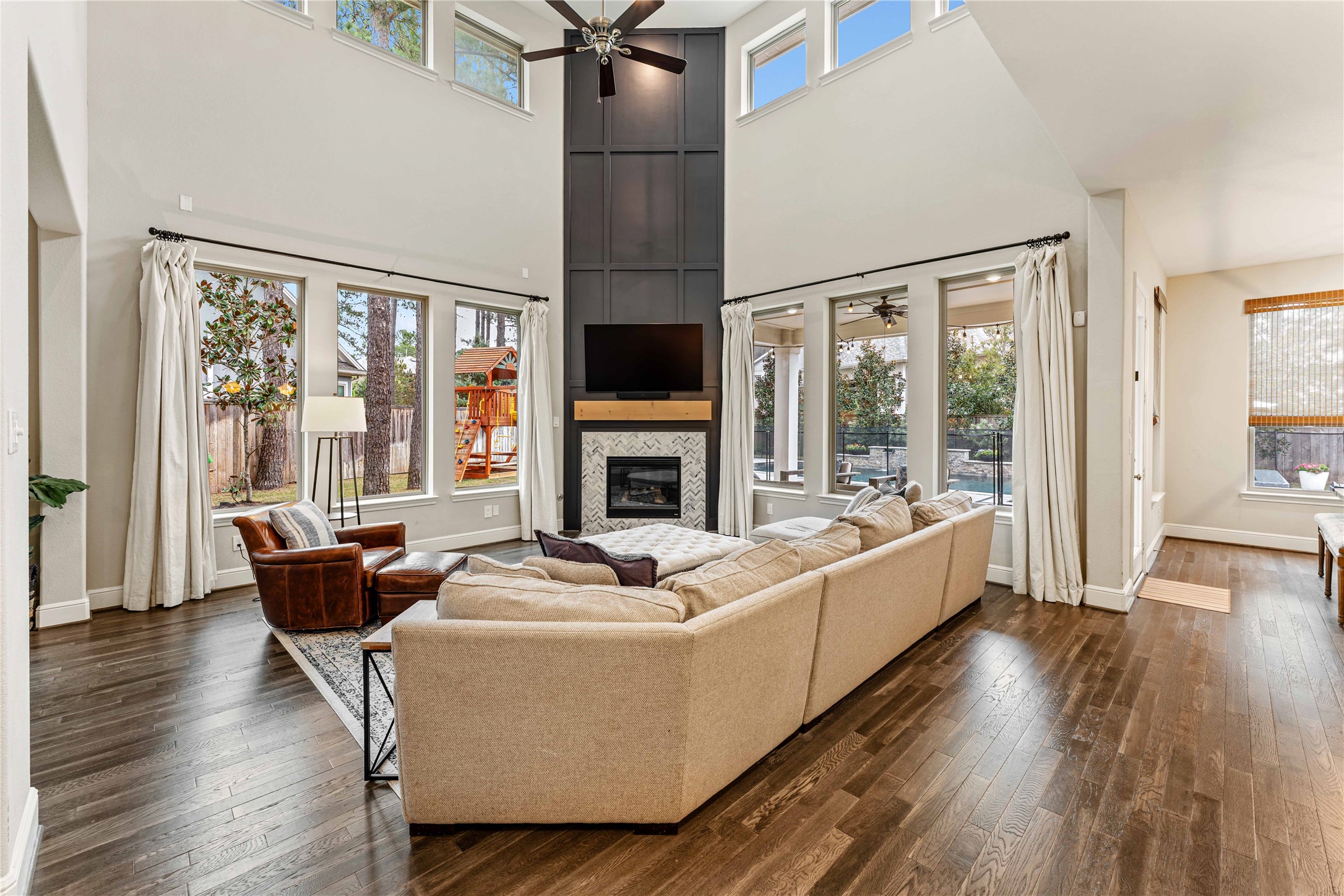 155 Rockwell Park Spring, TX 77389 - Photo 10 of 41 The spacious living room features high ceilings and a completely remodeled fireplace with a custom accent wall. Perfect for entertaining or relaxing, it seamlessly connects to the outdoor space through multiple windows.