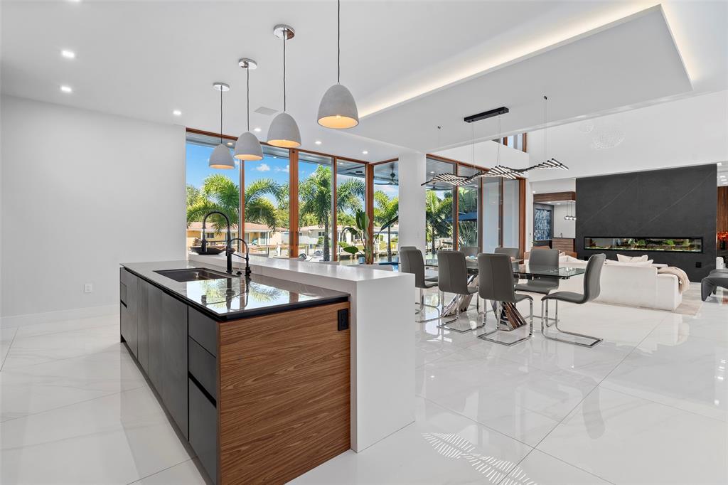 2631 Northeast 48th Court Lighthouse Point, FL 33064 - Photo 19 of 74 a kitchen with stainless steel appliances kitchen island granite countertop a sink a stove and a flat screen tv