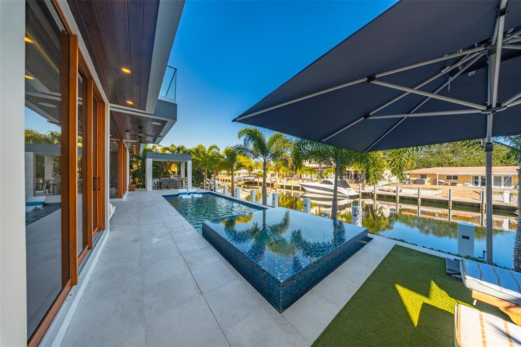 2631 Northeast 48th Court Lighthouse Point, FL 33064 - Photo 66 of 74 a view of swimming pool with chairs in patio