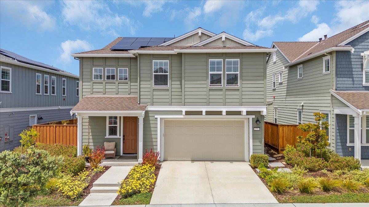 a front view of a house with a yard and potted plants