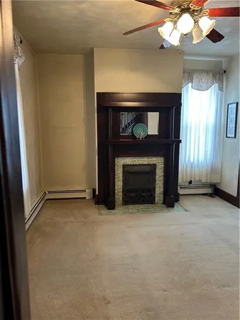a view of an empty room with a fireplace and a window