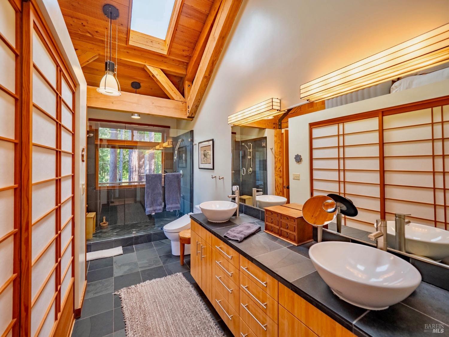 10951 Big Meadow Road Philo, CA 95466 - Photo 14 of 46 Primary ensuite bath - slate countertops and flooring, walk-in shower overlooking a redwood grove and a Toto SanaGlos commode - Luxurious.