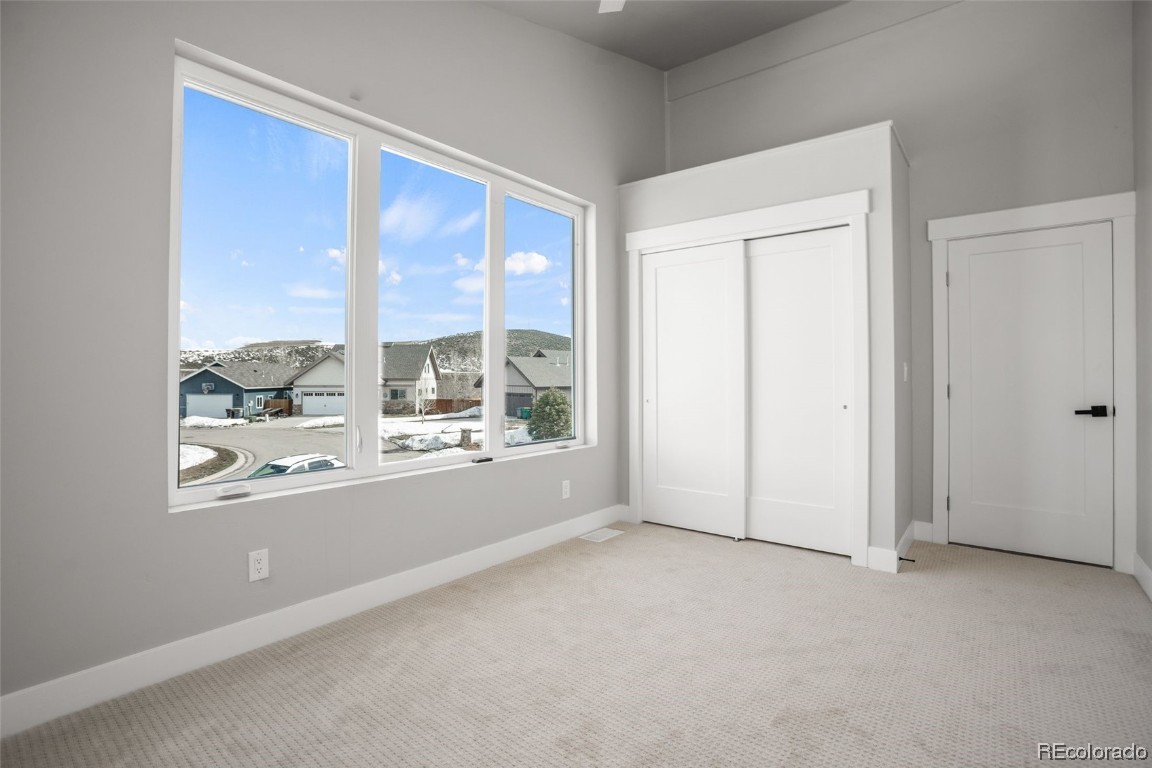 932 Dry Creek Road Hayden, CO 81639 - Photo 18 of 24 an empty room with windows lake and mountain view