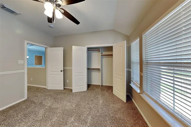 a view of empty room with window and ceiling fan