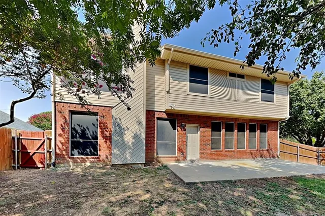a view of a house with large windows and a tree